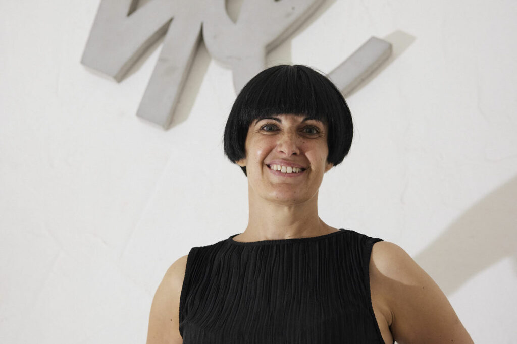 Das Foto zeigt die Künstlerin Petra Polli im Lasserhaus vor ihrem Kunstwerk "LIKE, 2016"