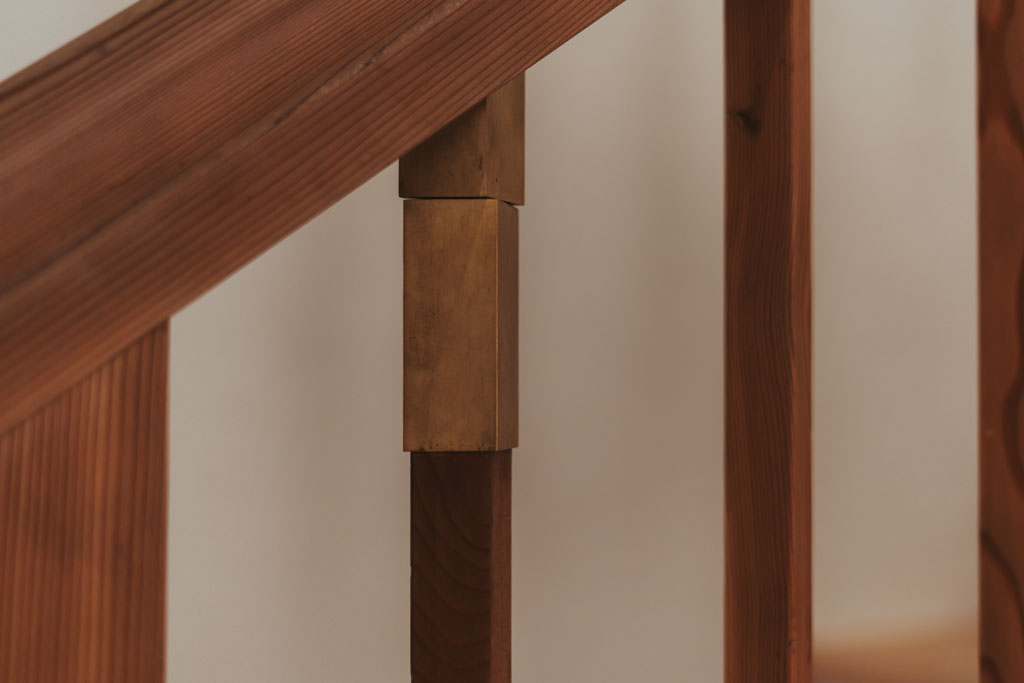 Das Foto zeigt die Strebe eines Treppengeländers. Wenn die Strebe um die Hochachse gedreht wird, wird ein Uhrwerk aufgezogen. Je nachdem, wie weit das Uhrwerk aufgezogen wurde, gibt es für eine gewisse Zeit klopfende Geräusche von sich. Das Kunstwerk Stammt von Alexander Wierer.