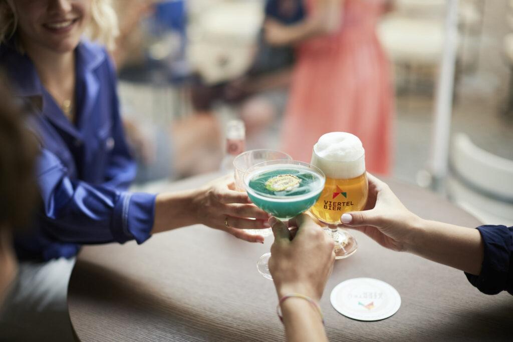 Das 3 Hände mit verschiedenen Getränken in der Viertel Bar in der Brixner Innenstadt beim Anstoßen