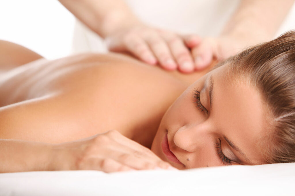 Eine Frau liegt entspannt auf einer Liege und wird massiert