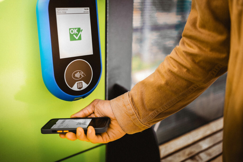 Eine Person scant den Digitalen Guestpass ab einer Haltestelle von öffentlichen Verkehrsmitteln in Südtirol